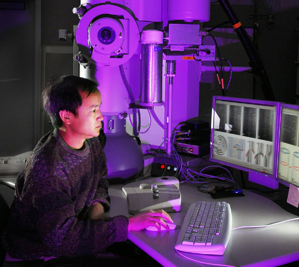 A researcher sits in front of a combination TEM-STM microscope.  This machine allows scientists to study nanoparticles like buckyballs, which may have applications ranging from medicine delivery to solar panels.